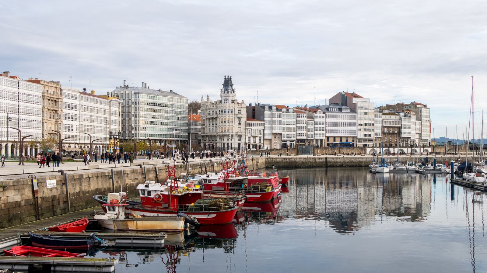 Botes amarrados en el muelle, con la ciudad al fondo