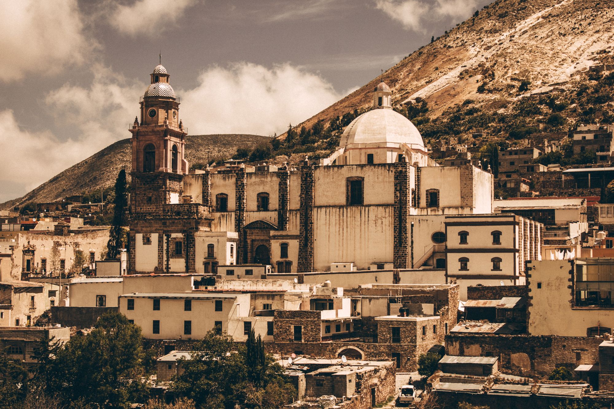 El pueblo de piedra con su iglesia de cúpula, bajo la sierra