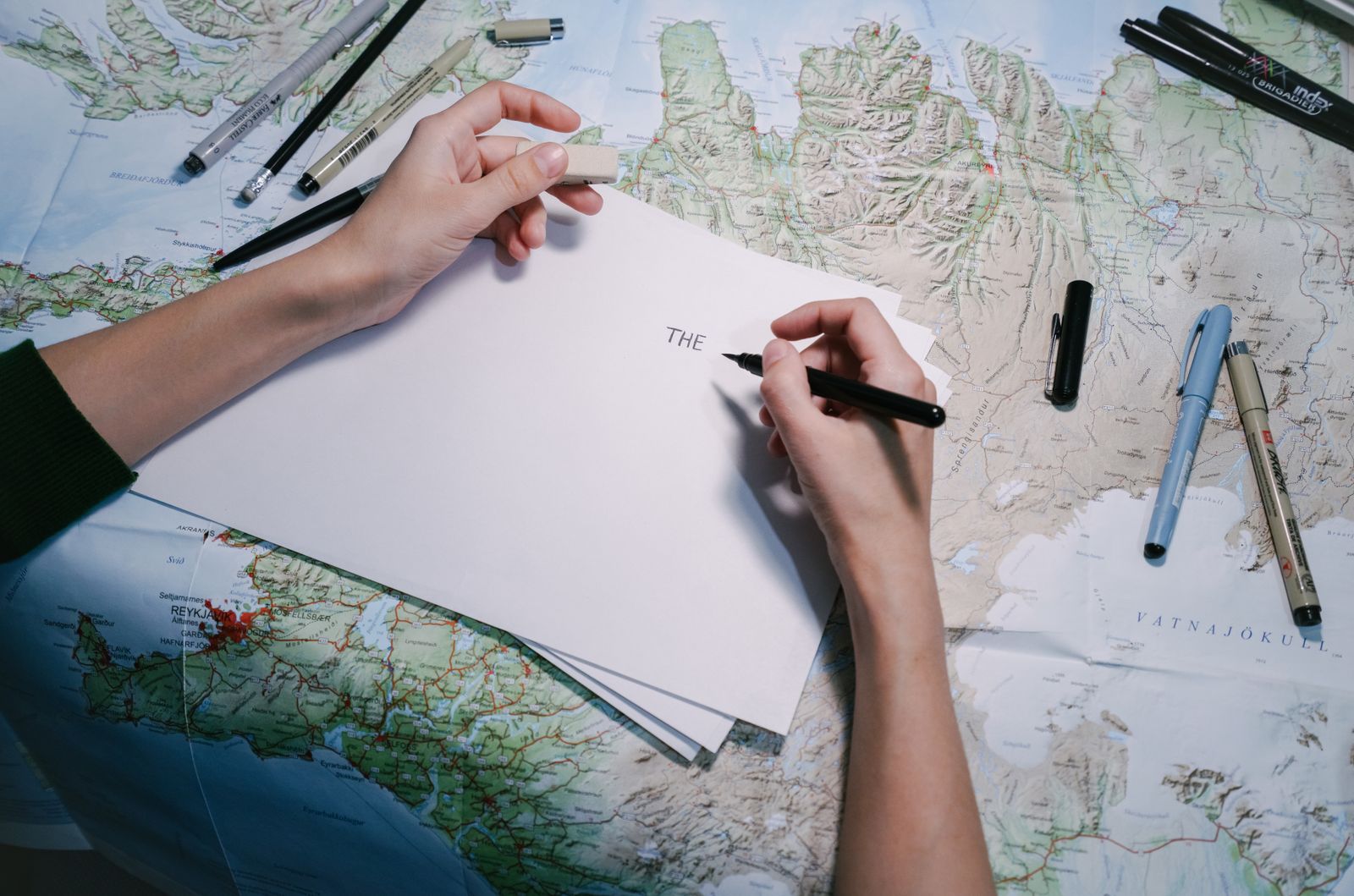 Manos anotando sobre un mapa desplegado en la mesa