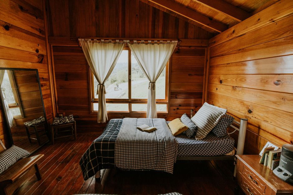 Recámara de la cabaña, madera y cobijas de cuadros